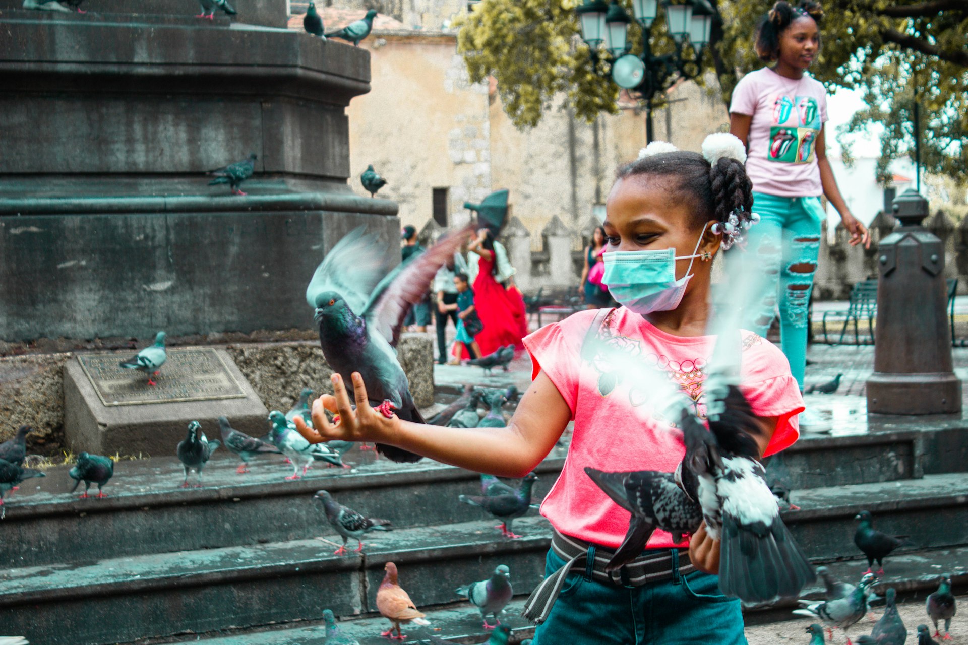 woman in red shirt and green skirt holding water fountain